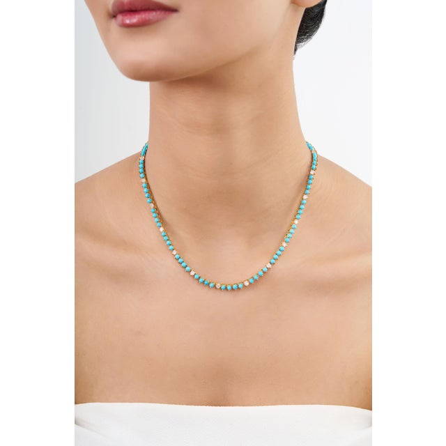 This tennis necklace features 13.8 carats of round-cut Sleeping Beauty turquoise, set in 18K yellow gold. Each turquoise...