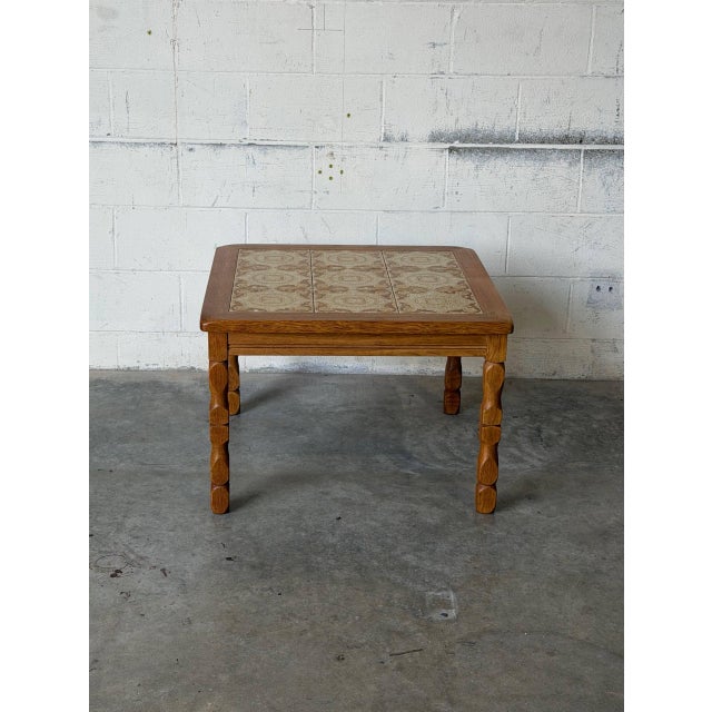 This charming square coffee table features an inset ceramic tile top and classic turned legs. Built with traditional...