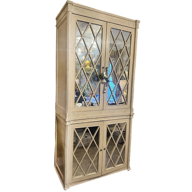 A handsome media armoire with mirrored cabinet doors. A mixture of classical English and modern influences. Metal handles...