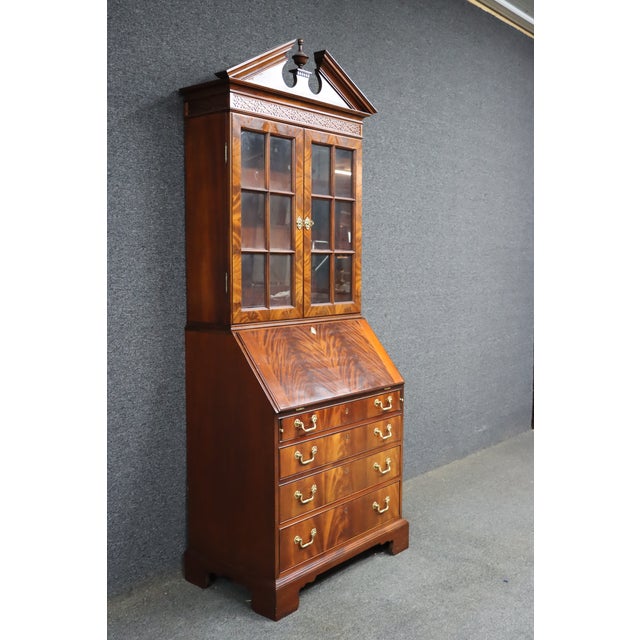 Elegant Council Craftsmen mahogany secretary bookcase featuring a classic broken pediment crown with center finial, richly...