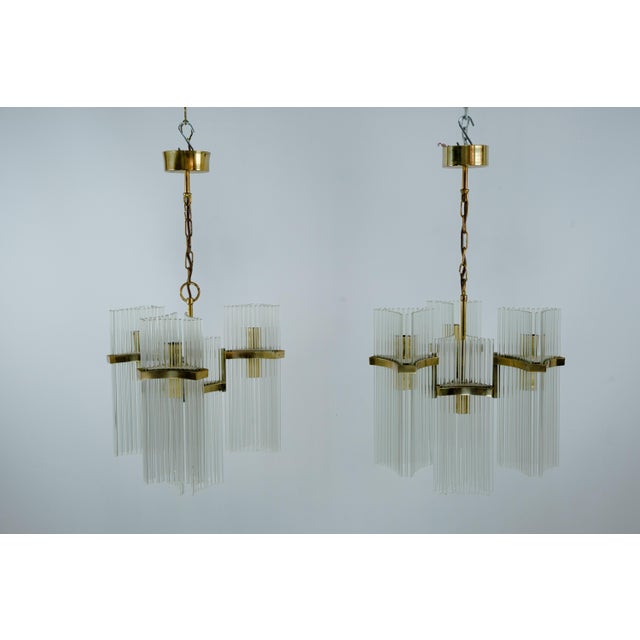 Elegant pair of Italian chandeliers designed by Gaetano Sciolari and produced in the 1970s. Each fixture features a...