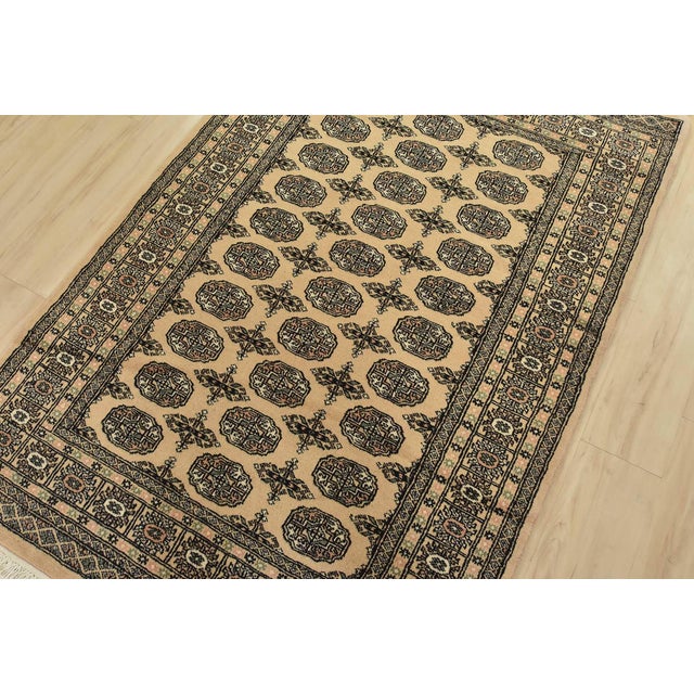 A tribal Bokhara rug hand-knotted with fine wool on a cotton foundation. This rug features rows of repeating medallions...