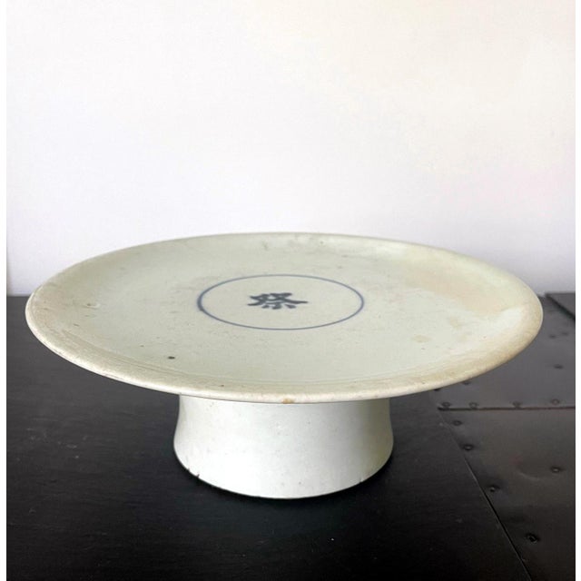 A ceramic dish with high cylindrical foot in white glaze with a cobalt blue underglaze inscription from Korea, circa...