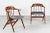A pair of vintage sculptural armchairs in the style of Illum Wikkelsø. The chairs are made of solid teak in delicate...