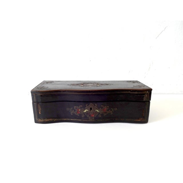 An antique, c. 1860, French Boulle work glove box, with a hinged top and curved, drop-down front. Black ebonized lacquer...