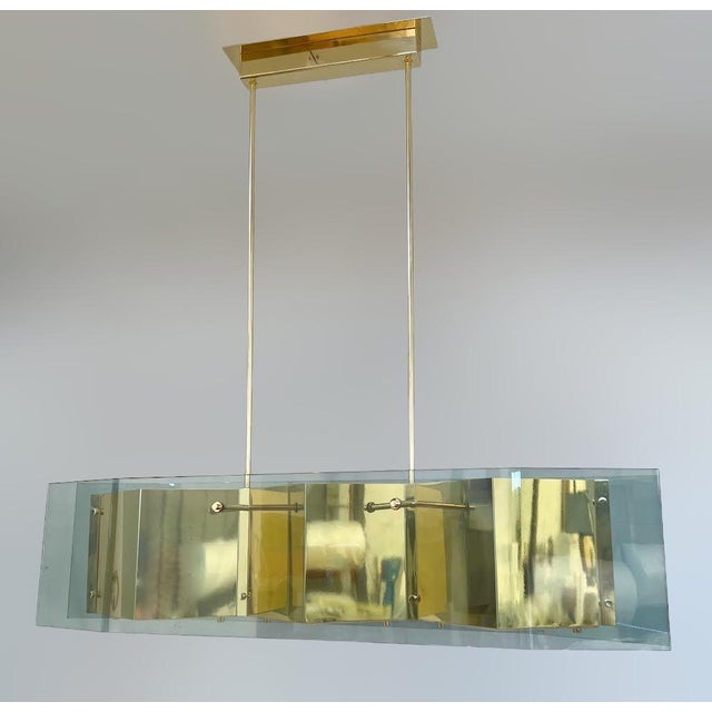 Italian modern chandelier with elongated light green glass panels mounted on polished brass frame with diamond shaped...