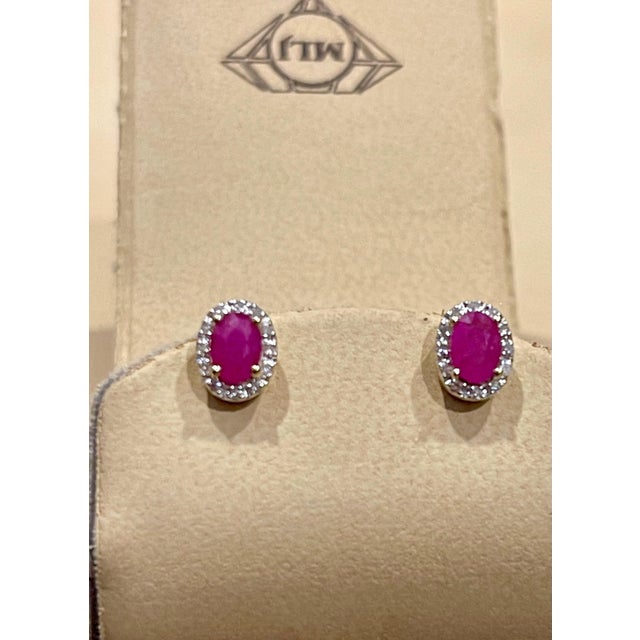 This luxurious pair of ruby halo stud earrings is designed in 14K Yellow gold. The oval red Rubies are surrounded by a...