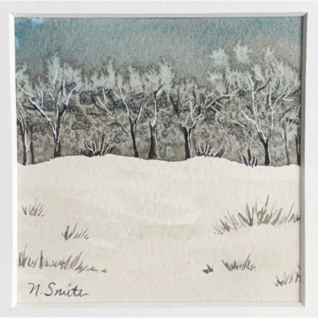 This tranquil scene showcases a lightly frosted forest with subtle earthy tones and textured grasses poking through the...