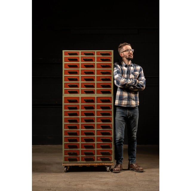 Vintage wooden parts cabinet on a steel base with wheels. This piece features 102 drawers of almost uniform size (51...