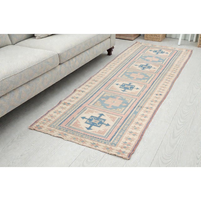 This is a vintage Turkish Oushak rug from the Mid 20th Century. The piece was hand-knotted.