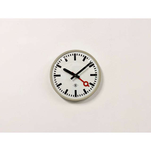 Wall clock produced by TN Telefonbau und Normalzeit in Germany during the 1960s. It features a grey bakelite frame, a...
