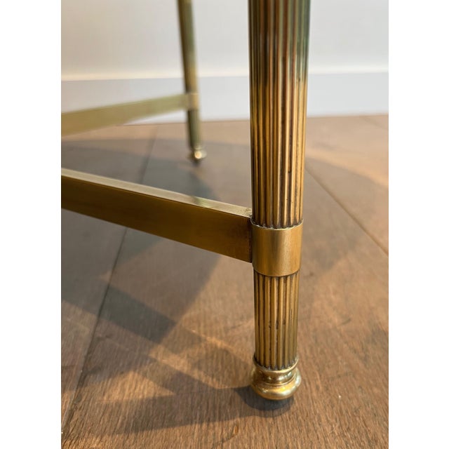 This round coffee table is made of brass with a black lacquered glass top. This is a French work by Maison Jansen. Circa 1940