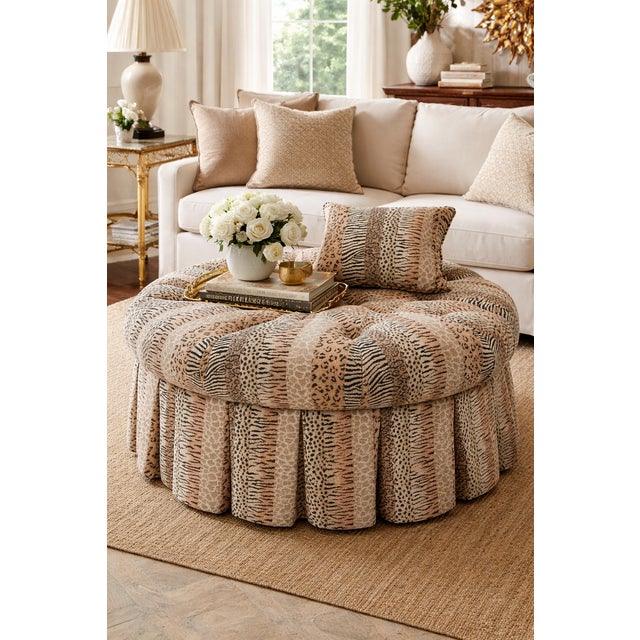 A substantial, fully upholstered cocktail ottoman featuring deep radial tufting and a tailored skirt, executed in a finely...