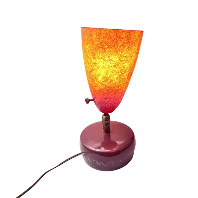 This Atomic Age lamp exemplifies mid-century modern design from the 1950s-1960S, featuring a fiberglass pink conical shade...