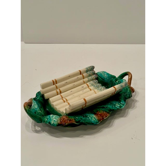 Sensational 19th century French majolica serving dish in a gorgeous shade of emerald green with white asparagus lying on top.