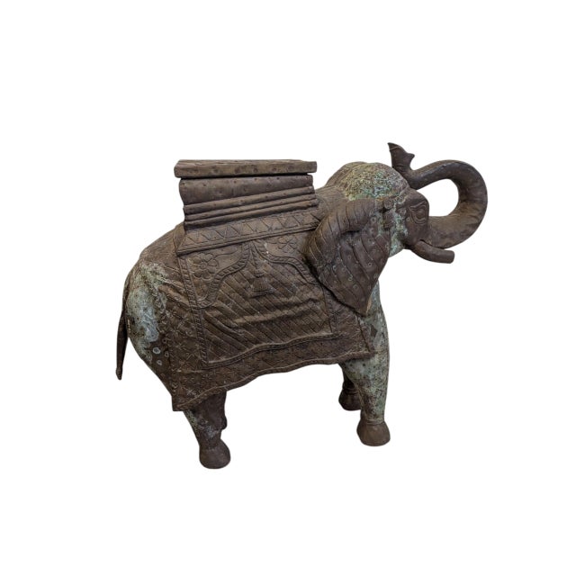 This gorgeous and unique hand-carved wood elephant plant stand has the LOOK. Featuring hammered bronze cladding and the...