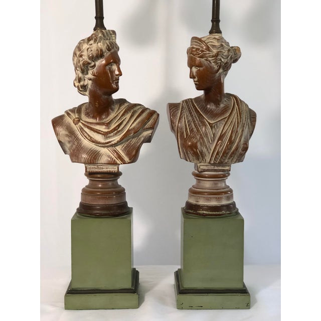 A stylized pair of hand-carved cerused oak neoclassical bust lamps on plinth bases.