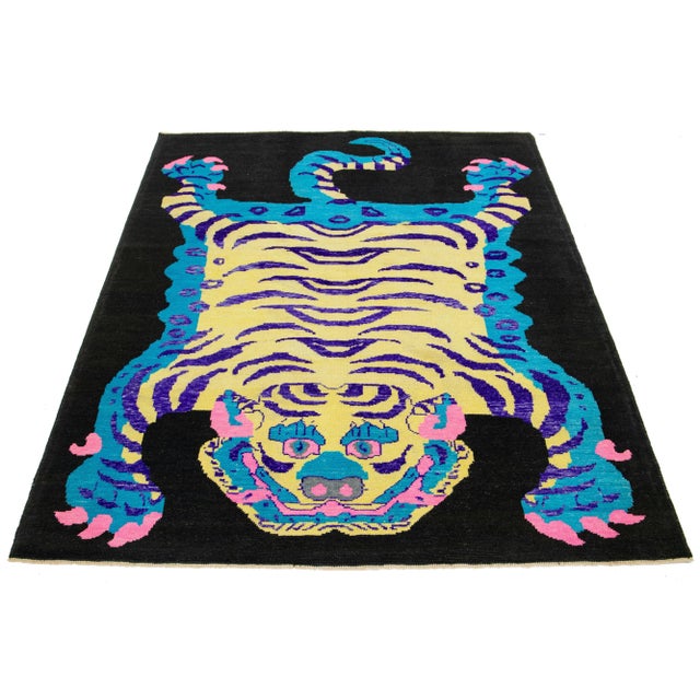 This beautiful handmade Turkish Art Deco wool rug has a black field. It features blue, beige, purple, and pink accent...