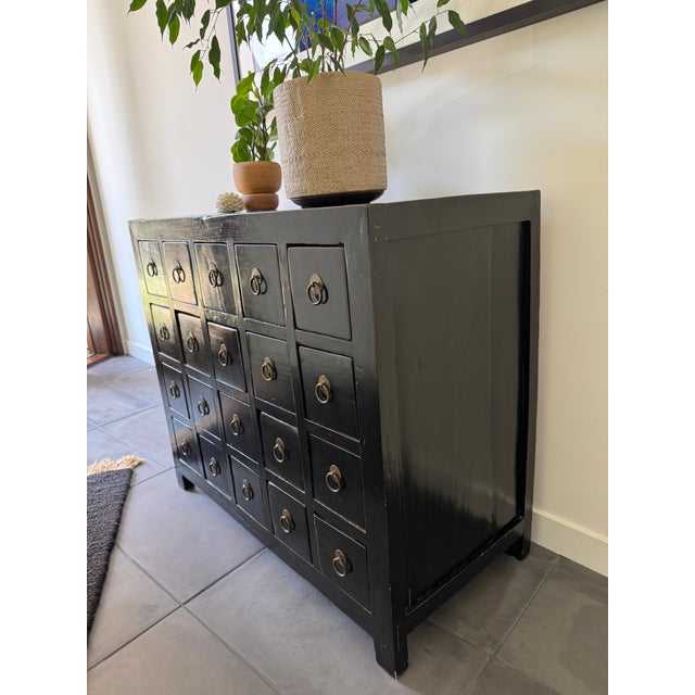 Chic blend of traditional and contemporary style, this vintage apothecary chest is solid wood with black lacquer finish...