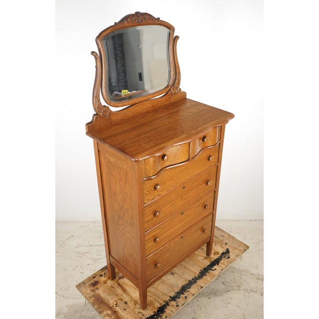 Vintage Traditional style tall dresser in medium stained tiger oak with six dovetailed drawers and a beveled glass mirror....