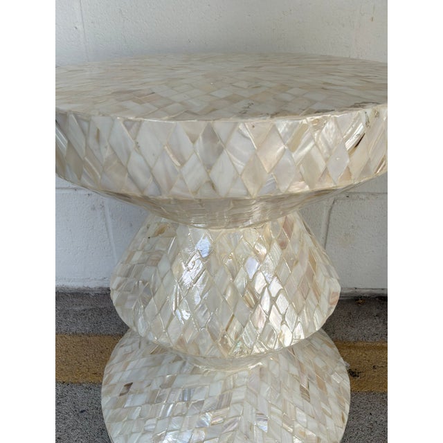 Stylish Mother of Pearl Round Accent Table, geometric mosaic pattern, hourglass inspired silhouette. Showroom floor sample.