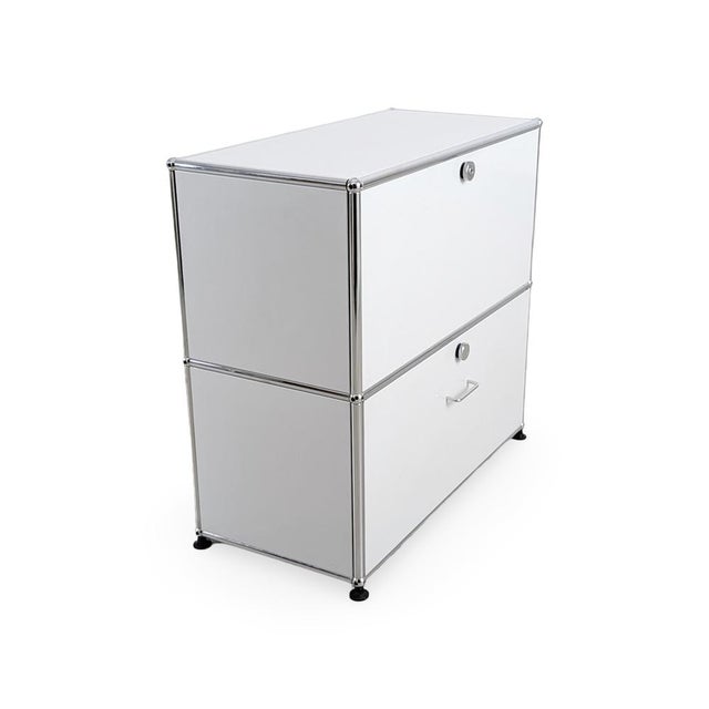 We are offering a beautiful white USM Haller sideboard with two compartments for sale. The upper section features a drop-...