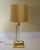 Mid Century Hollywood Regency style table lamp has a acrylic glass cylinder stem supported with a brass tume and base with...