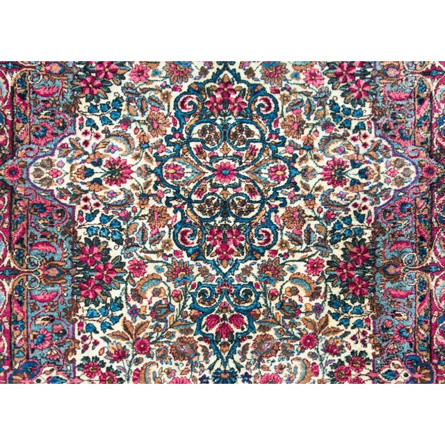 A beautiful early 20th century Persian Kirman rug with an all-over mirrored densely woven floral pattern with myriad...