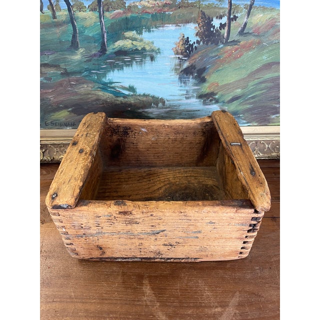 A charming possibly antique wooden box showcasing early craftsmanship and utilitarian design. This hand-hewn storage box...