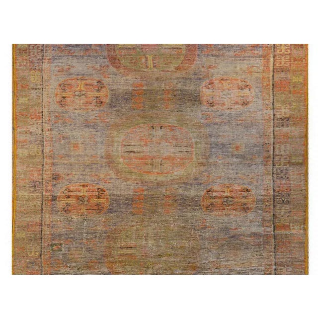 A handsome early 20th century Central Asian Khotan rug with three circular medallions in the center amidst a field of...