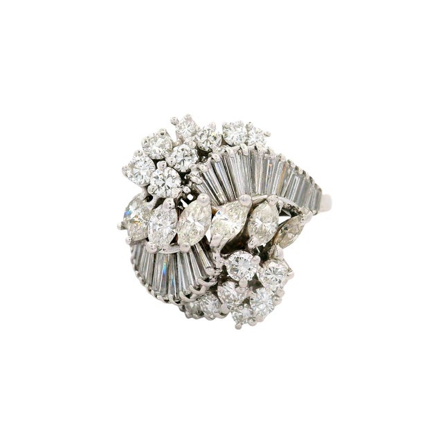 A captivating cocktail ring showcasing a dazzling array of round, baguette, marquise white diamonds. The intricate design...