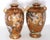 Heavily gilded matched pair of antique Japanese porcelain satsuma vases. Interesting and varied faces all around, with...