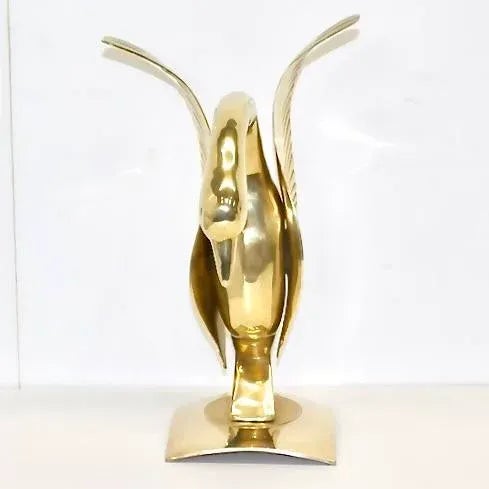 Hollywood Regency style solid brass swan on a concave base. Dimensions: 18" H x 12" D x 7.5" W.