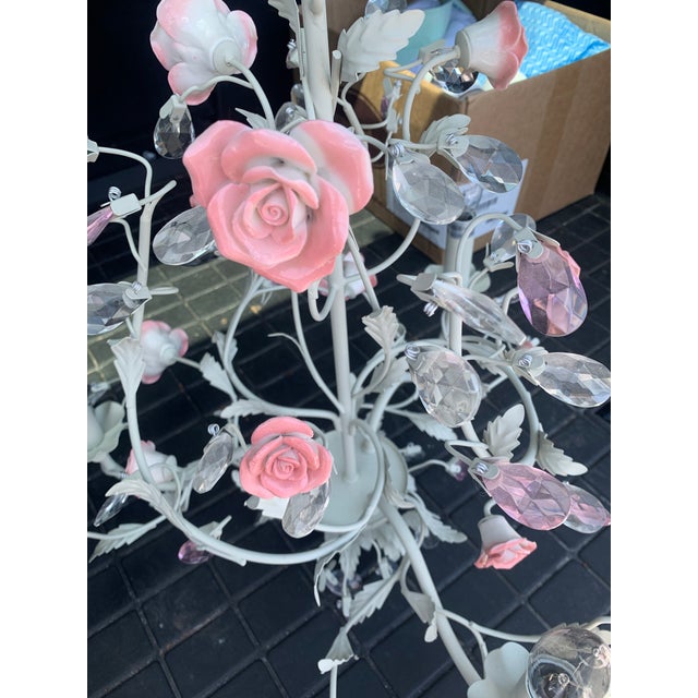 Crystal chandelier with delicate ceramic rose accents. Base is a light gray-white. Perfect for tea rooms or young princess...