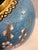 A vintage cloisonné vase featuring a delicate cherry blossom motif set against a textured blue enamel background. The...