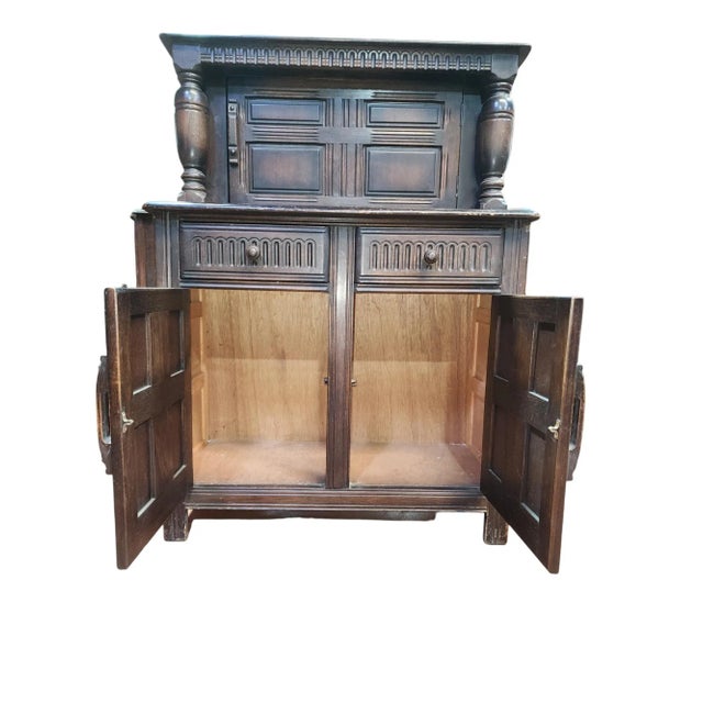 Beautiful slimline English oak court cupboard in Gothic Revival style, circa 1940s, with large opening top cupboard, twin...