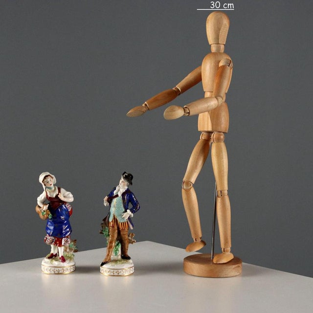 A pair of polychrome German porcelain figurines, 'Peasant Woman and Hunter'. Very finely crafted. Hallmark under the base....