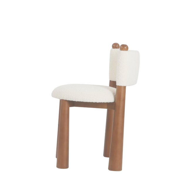 Meet Taliathe dining chair that's equal parts cozy and chic. With its cloud-like white boucle upholstery and sleek wood...