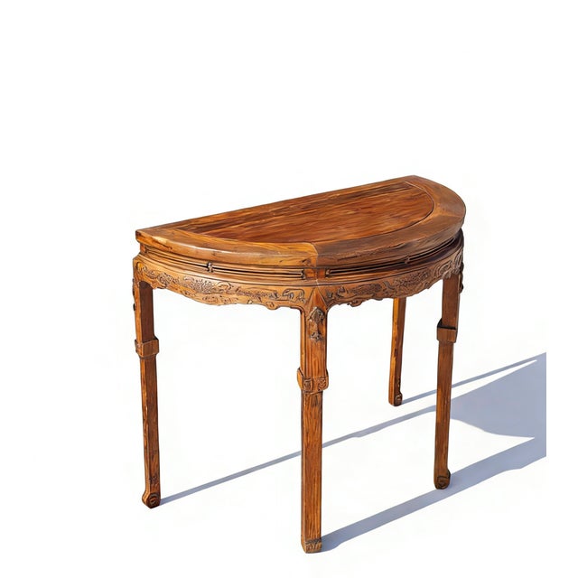 This semi-circular accent table, known as a yanyuezhuo or "half-moon" table, is made from solid elm with a rich, warm...