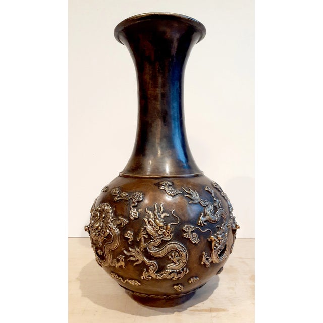 Chinese bronze nine dragon fengweizun, a finely formed, long necked phoenix-tail shape vase with nine highly detailed,...