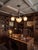 The chandelier features a patinated solid brass frame with elegantly curved S-scroll arms and classicist relief detailing...