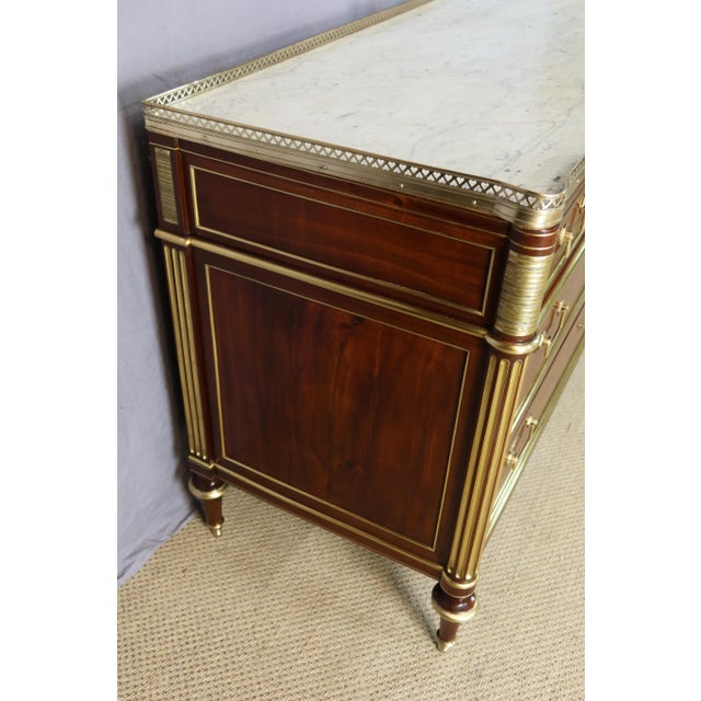 A Louis XVI mahogany commode from the late 18th century. It features three large drawers and rests on four toupie feet....