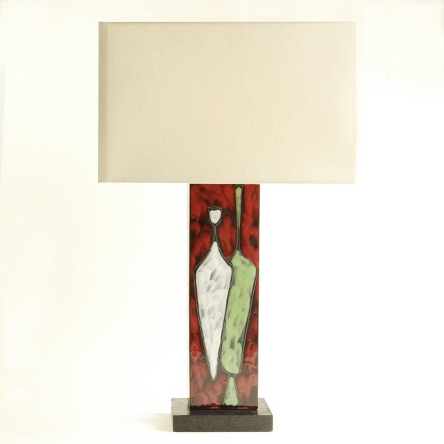Ceramic table lamp features a rectangular body mounted on a dark wooden base with a motive of stylized vases glazed in...