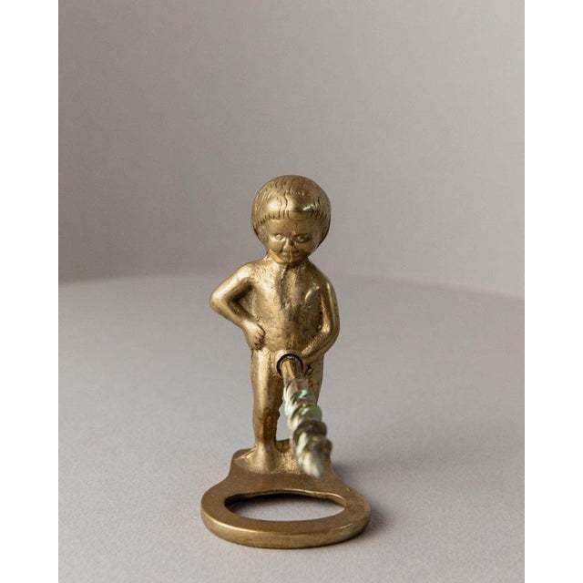 This vintage metal bottle opener in the shape of a boy figurine is a unique and charming piece from the 1960s, designed in...