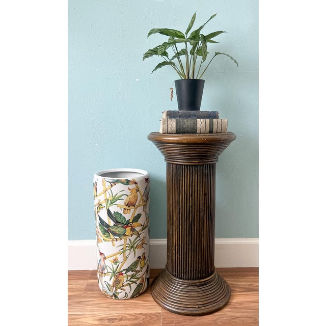 Exquisite, 1970's pencil reed/ rattan pedestal featuring a fluted column form with a round top decorated in an eye-...