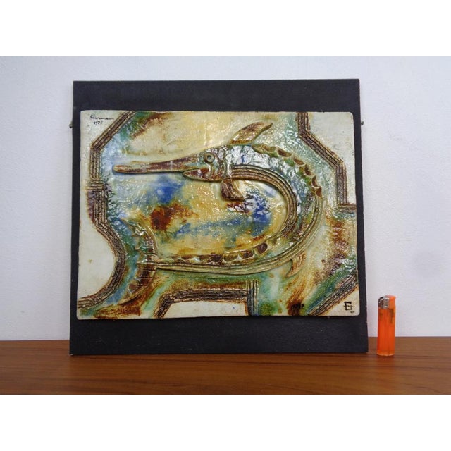 Studio ceramic wall relief of a garfish. Mounted on a wooden plate. Dated and signed several times. Dimensions with and...