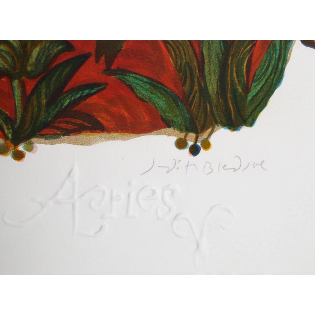 Surrounded by a glowing fire, the ram representing the Zodiac sign of Aries runs across the grass as it turns its head...