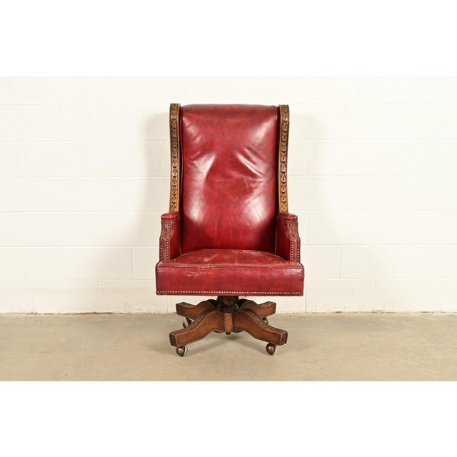 An exceptional Nordic Rustic European carved solid oak and leather high back executive swivel office desk chair By...