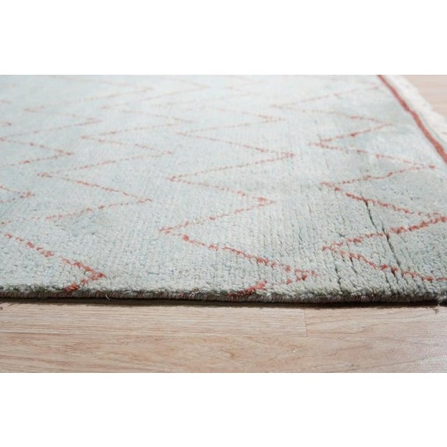 This blue wool rug features a hand knotted pile construction in the style of a traditional Berber carpet. Handcrafted in...