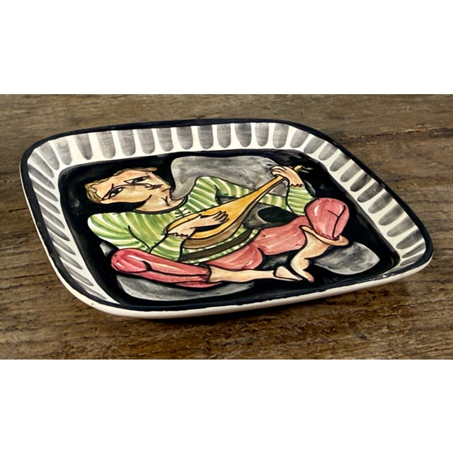 This mid century Italian ceramic wall plaque was created by Giovanni Petucco. The piece features a hand painted troubadour...